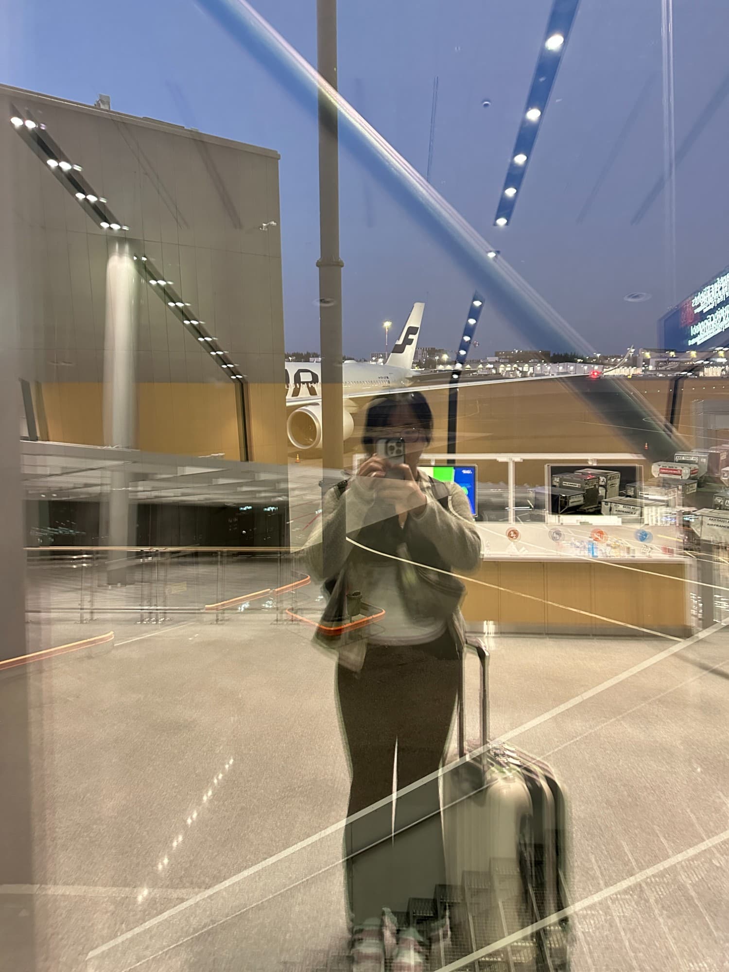 Glass reflection self-portrait at an airport departure gate